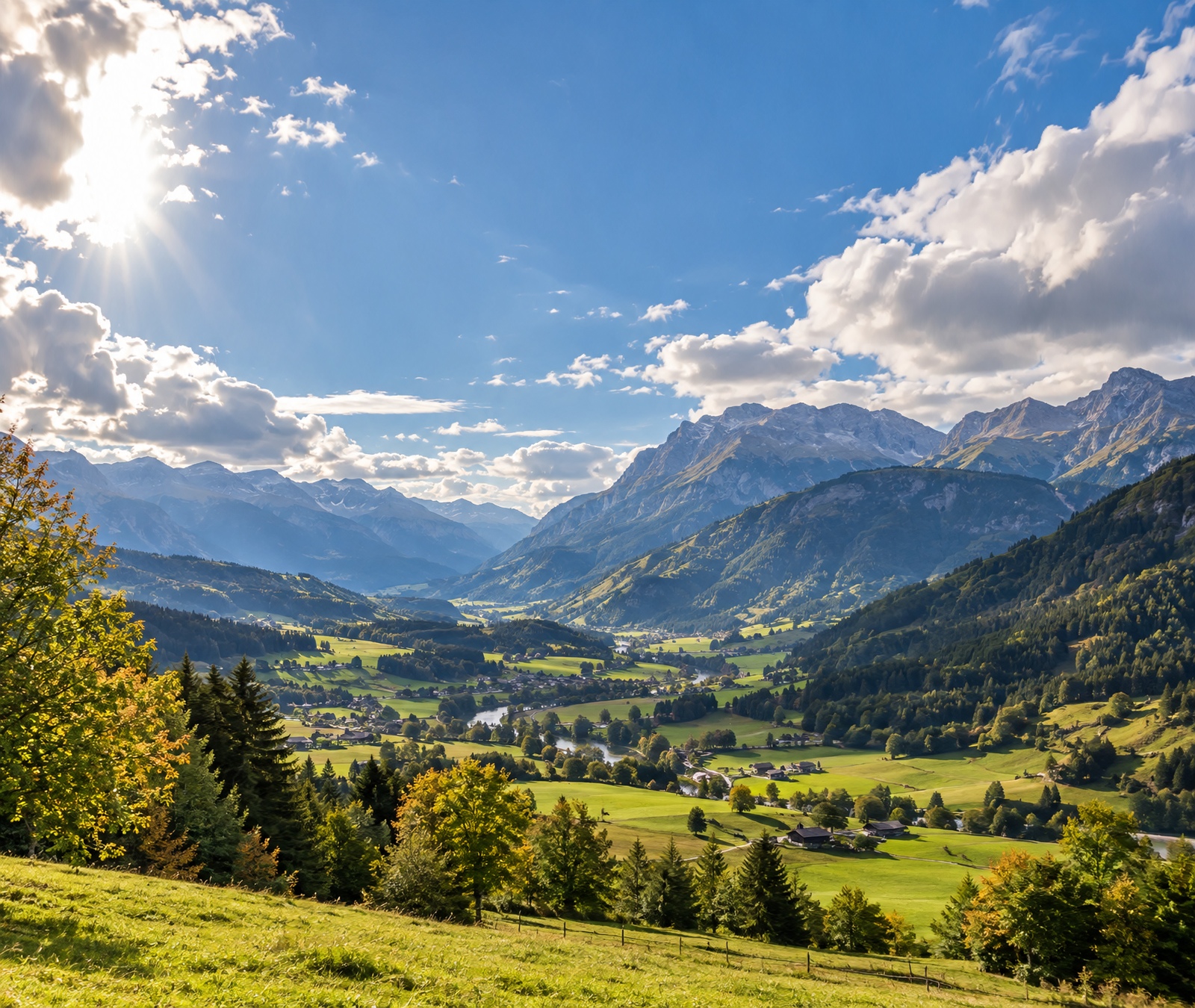 Sonniges österreichisches Alpental mit grünen Wiesen und markanten Berggipfeln