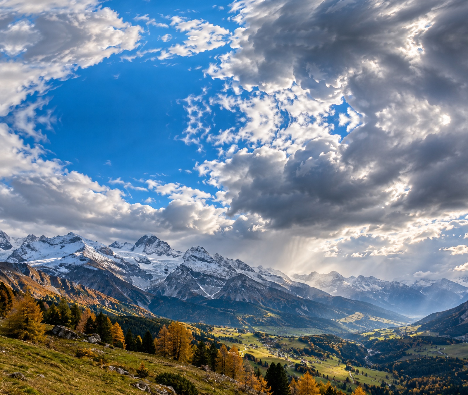 Österreichisches Alpental im Herbst mit wechselnder Bewölkung und Schnee auf hohen Gipfeln als Symbolbild für das Bergwetter am Samstag.