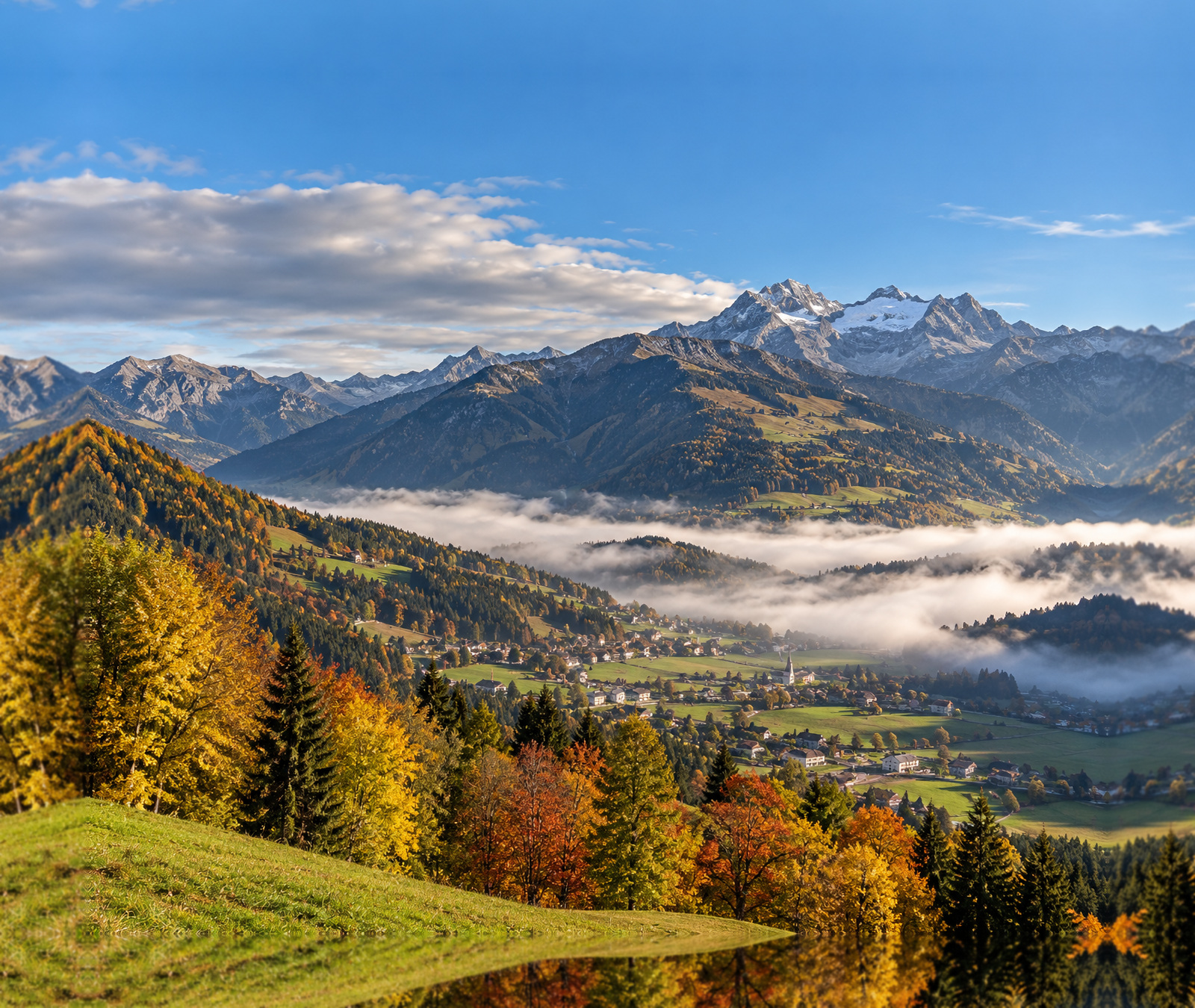 Österreichische Herbstlandschaft mit Nebelfeldern im Tal und freundlichem Himmel als Symbolbild für den sonnigen Dienstag.