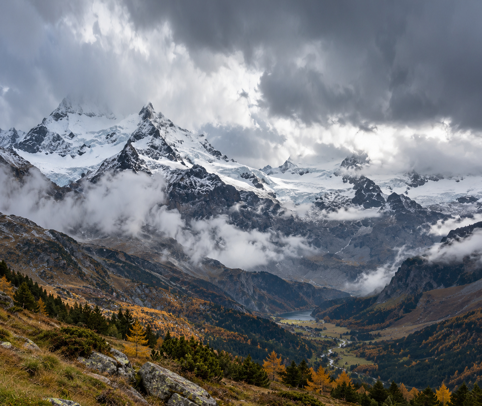 Symbolbild österreichischer Hochalpen mit Gletscher, frischem Schnee in Gipfellagen und herbstlichen Hängen unter einer Kaltfront.