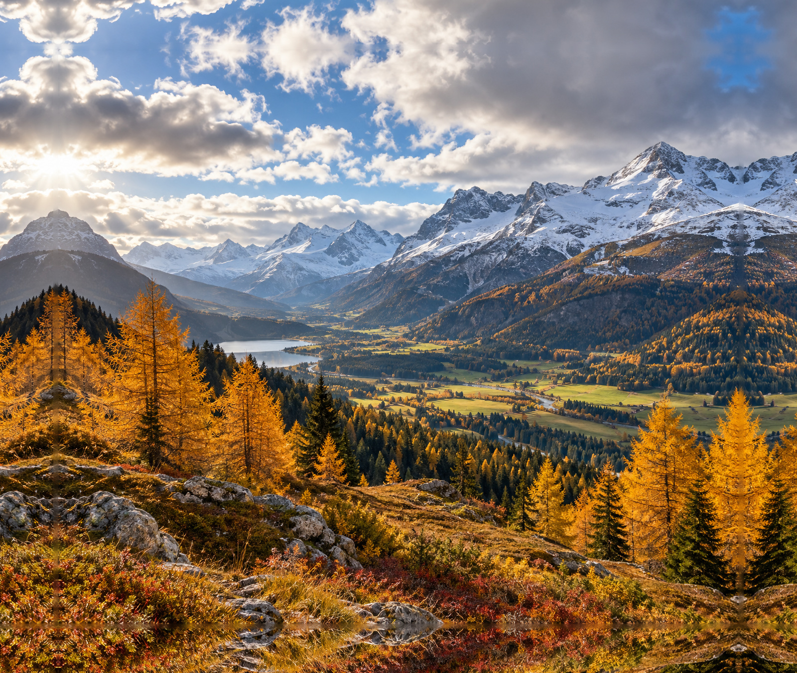 Österreichische Alpenlandschaft im Herbst mit sonnigen Abschnitten, Wolken und Schnee auf hohen Gipfeln